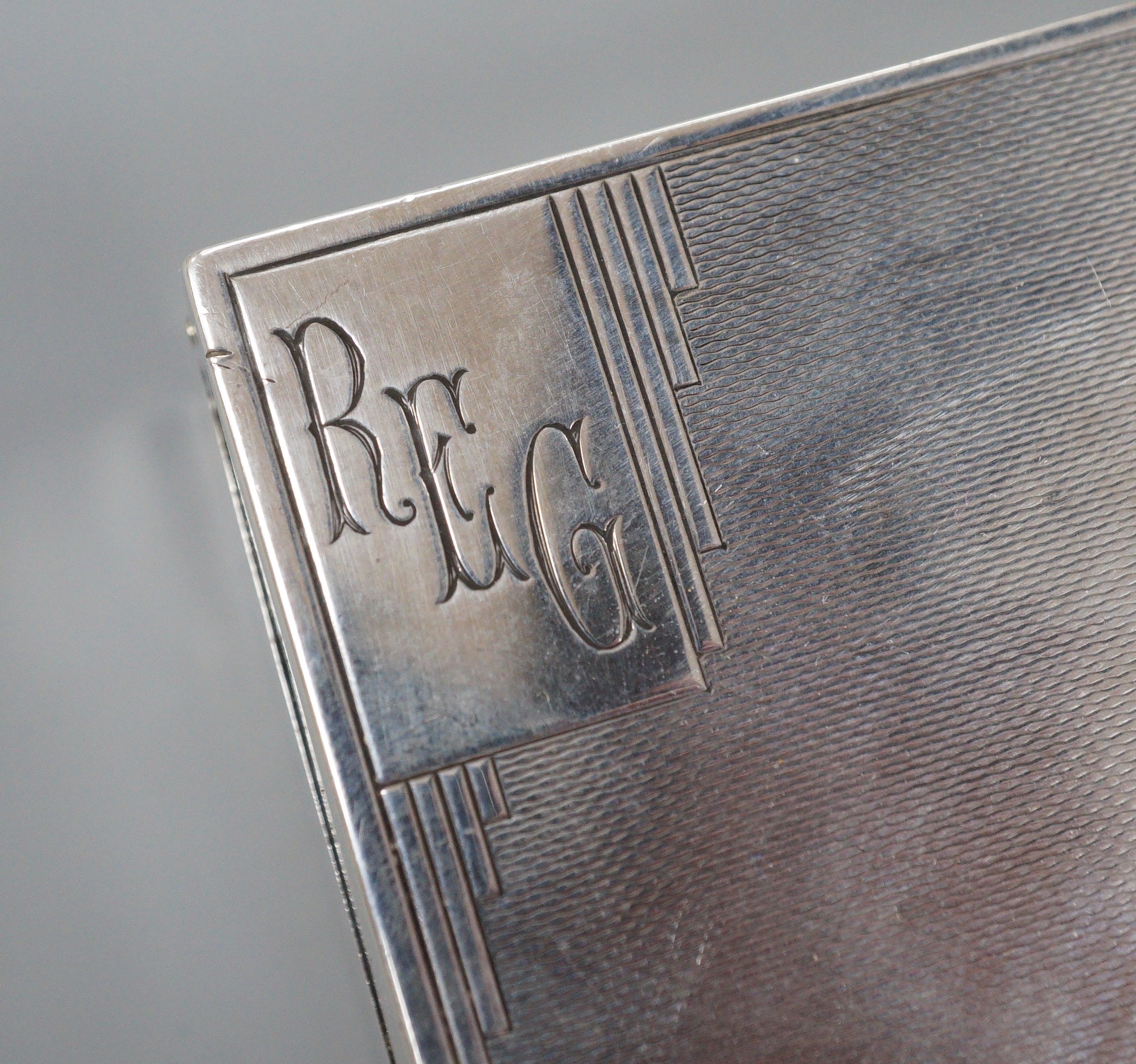 A George V engine turned silver rectangular cigarette box, Mappin & Webb, London, 1933, 12.8cm.